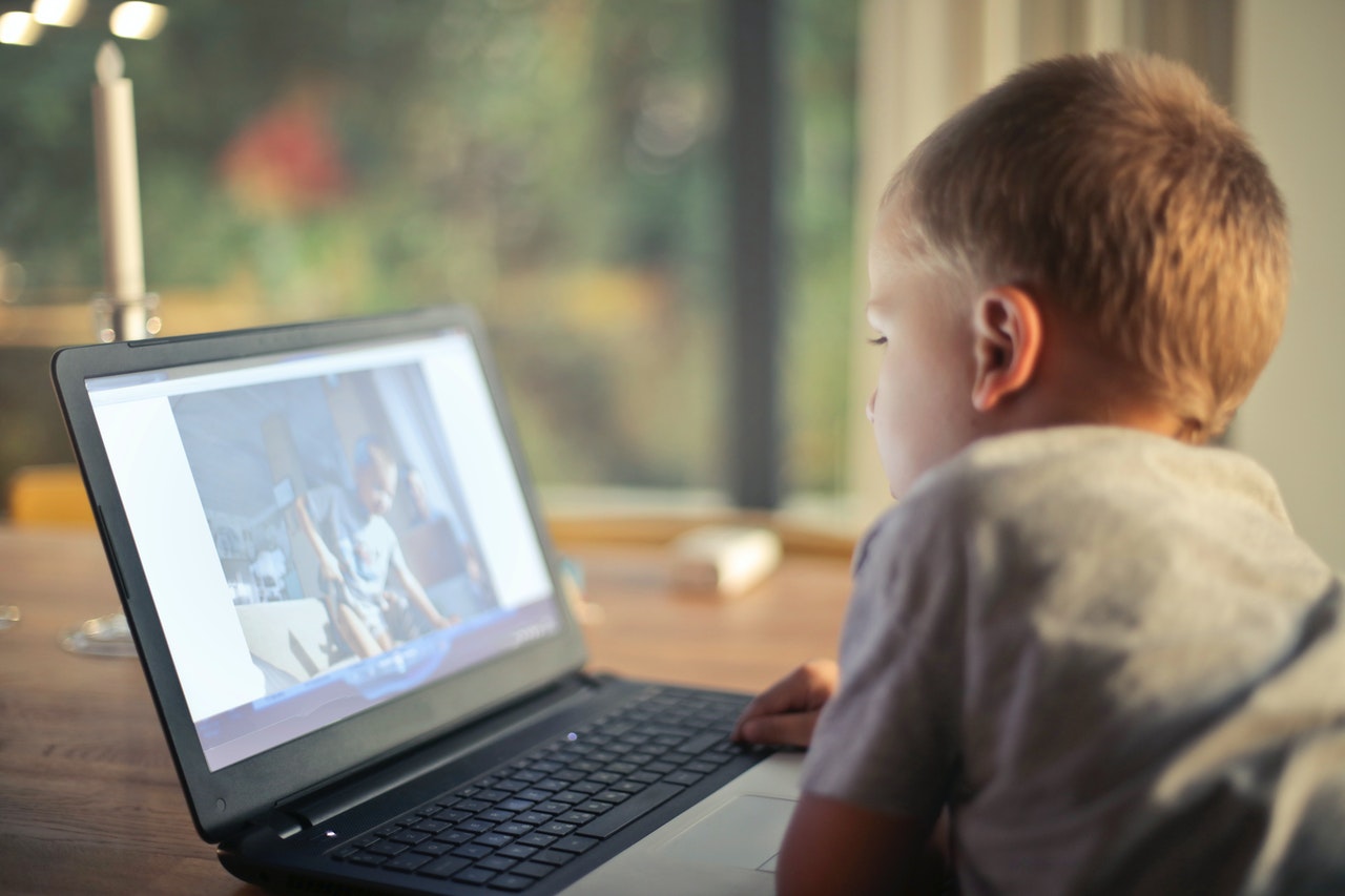 boy watching video using laptop 821948