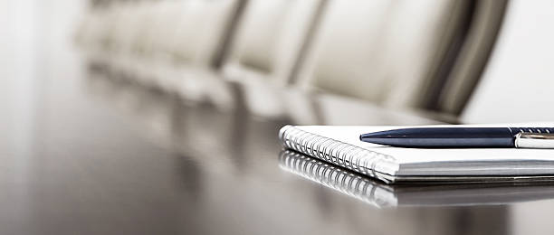 Closeup of notepad kept on table in empty conference room